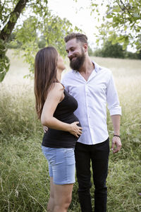 Rear view of couple standing on field