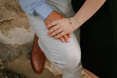 Detail of man and woman holding hands