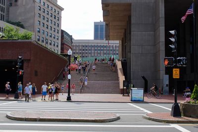 People walking on road amidst buildings in city