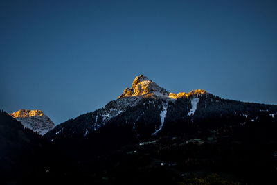 Low angle view of rocky mountains against clear sky