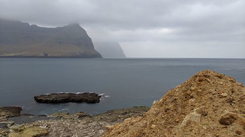 Rocks by sea against sky