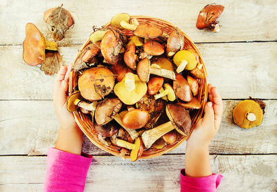 Cropped hand of woman holding food on table