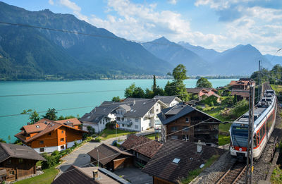 High angle view of train by houses against mountains