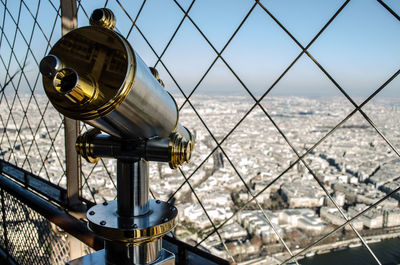 Close-up of cityscape seen through chainlink fence