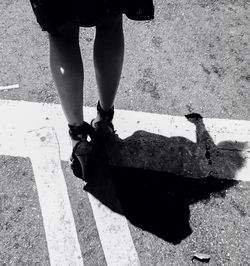 Low section of woman standing on road