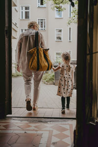 Senior woman walking with granddaughter seen through doorway