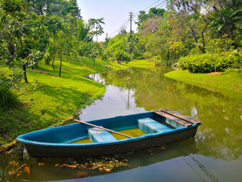 Boats moored in lake by trees