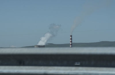 Smoke emitting from chimney against sky