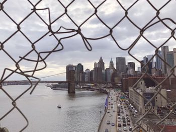 View of city buildings seen through chainlink fence