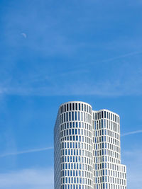 Low angle view of modern building against blue sky