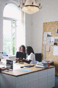 Multi-ethnic business people discussing at table in creative office