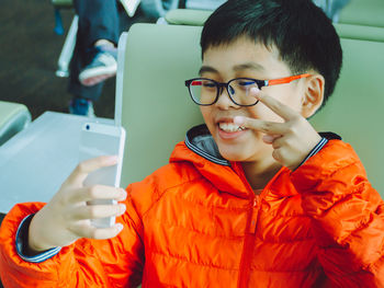 Smiling boy holding mobile phone