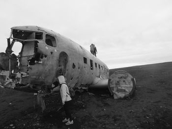 Abandoned airplane on airport runway against sky