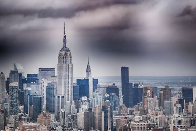 Skyscrapers in city against cloudy sky