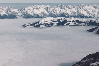 Scenic view of snowcapped mountains amidst clouds