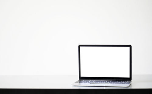 Close-up of laptop on table against white background