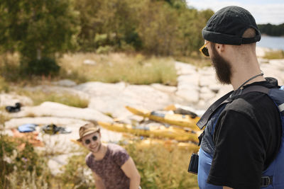 Men talking at coast, kayaks in background