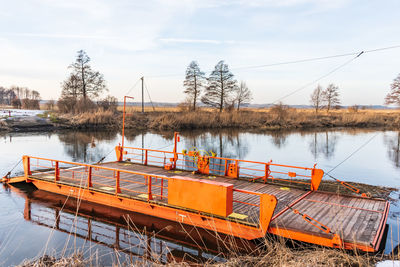 A orange cable ferry across a river or large body of water by cables connected to both shore.