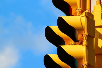 Low angle view of illuminated lighting equipment against blue sky