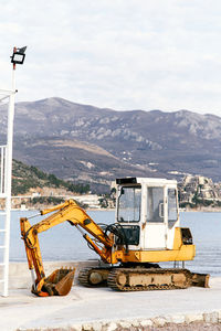 Construction site by mountains against sky