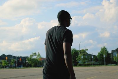 Rear view of man standing against sky