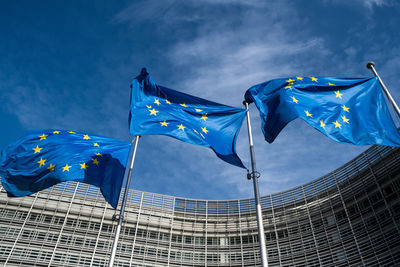 Low angle view of flags against blue sky