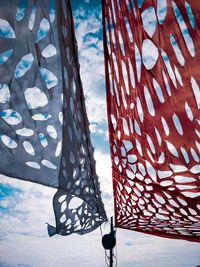 Low angle view of umbrellas on table against blue sky