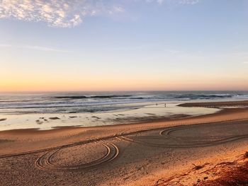 Scenic view of beach against sky during sunset