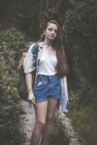 Young woman standing in forest