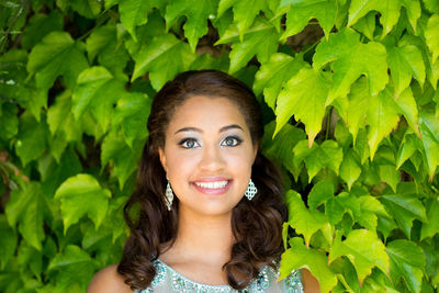 Portrait of smiling young woman by plants