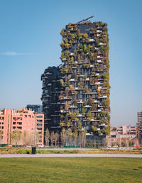 Built structure on field against buildings in city against clear sky