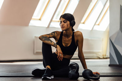 Full length of young woman sitting at gym