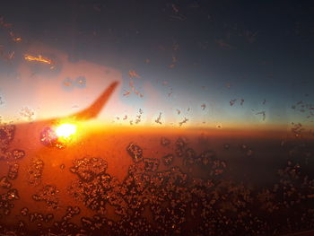 Raindrops on glass window during sunset