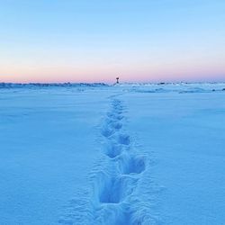 Scenic view of snow covered land against blue sky