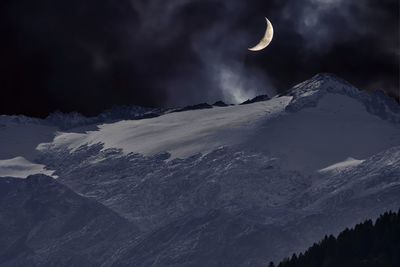 Scenic view of snowcapped mountains against sky at night