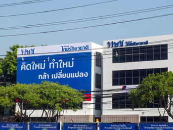 Low angle view of information sign against blue sky