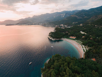 High angle view of sea by mountains against sky