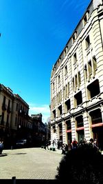 Buildings in city against blue sky