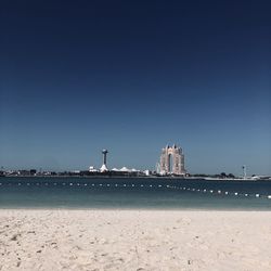 Building by sea against clear sky