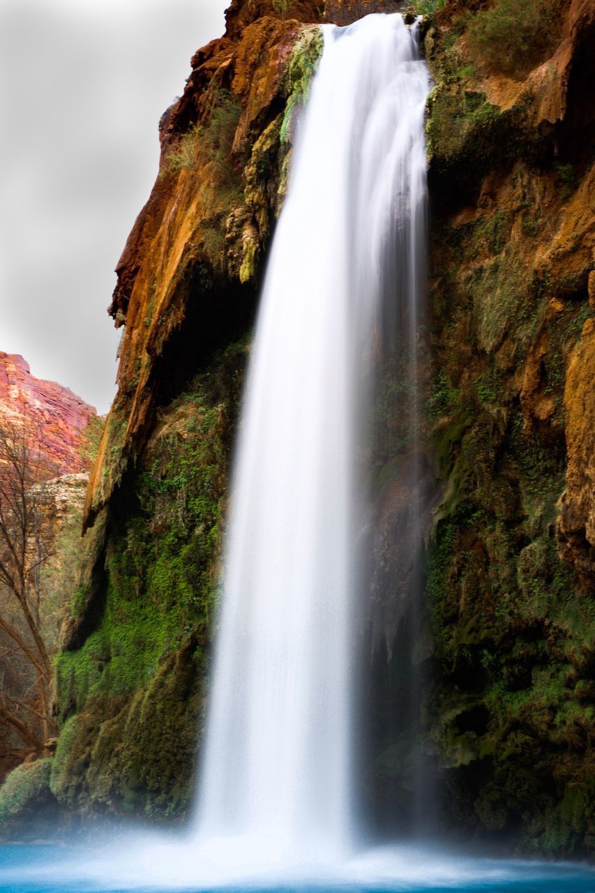 SCENIC VIEW OF WATERFALL ON ROCK FORMATION