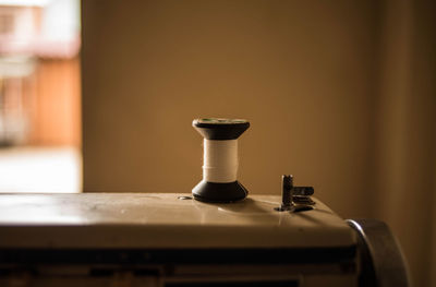 Close-up of sewing machine against wall at home