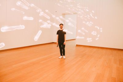 Full length of young man standing against wall