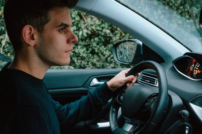 Young man sitting in car