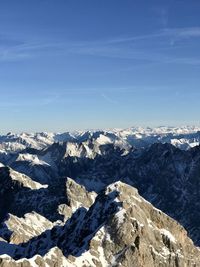 Scenic view of snowcapped mountains against blue sky