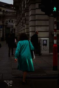 Rear view of a man walking in city at night