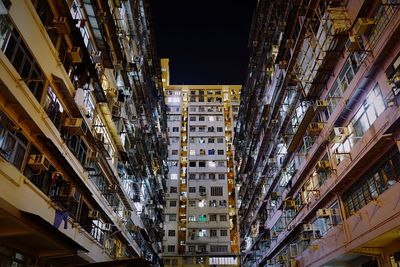 Low angle view of buildings against sky in city at night