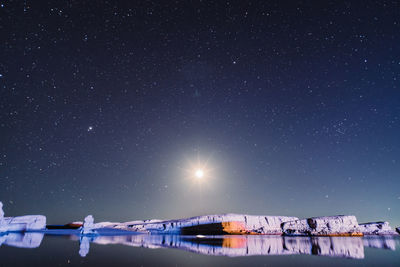 Scenic view of snow against sky at night