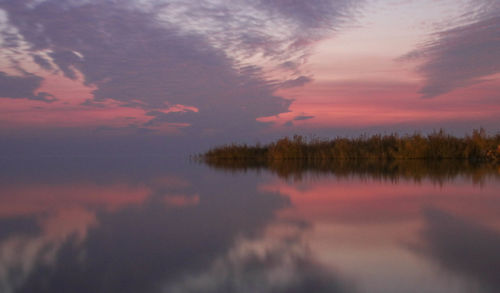 Scenic view of lake against sky at sunset