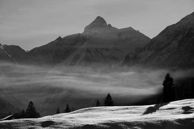 Scenic view of snow covered mountains against sky