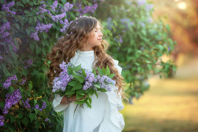 Beautiful woman standing by flower bouquet